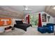Cozy bedroom featuring a ceiling fan, a large window with natural light, and a sloped, wood-covered ceiling at 16019 Chastain Rd, Odessa, FL 33556