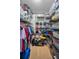 Well-organized walk-in closet with metal shelving, hanging clothes, hats, and storage containers at 16019 Chastain Rd, Odessa, FL 33556