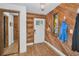 Entryway with wood-paneled walls, a stained glass window, and a closet with mirrored doors at 16019 Chastain Rd, Odessa, FL 33556