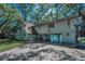 Spacious lakefront home with a brick driveway, attached carport, and a basketball hoop at 16019 Chastain Rd, Odessa, FL 33556