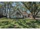 Charming two-story lakefront home with beautiful landscaping, mature trees, and large grassy yard at 16019 Chastain Rd, Odessa, FL 33556