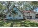 Well-maintained two-story home with lush landscaping, including a mature palm tree and flowering bushes at 16019 Chastain Rd, Odessa, FL 33556