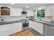 Well-lit kitchen featuring stainless steel appliances, white cabinets and ample counter space at 16019 Chastain Rd, Odessa, FL 33556