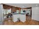 Open concept kitchen with island, wood accents, stone fireplace, and adjoining living and dining areas at 16019 Chastain Rd, Odessa, FL 33556