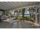 A covered outdoor deck and patio looks out on a sprawling backyard and lake at 16019 Chastain Rd, Odessa, FL 33556