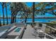Lakefront home with backyard patio area with a fire pit, built in seating and waterfront views at 16019 Chastain Rd, Odessa, FL 33556
