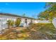 Lush backyard with mature trees, white privacy fence, and a cozy patio area at 2217 Stacy Ct, Dunedin, FL 34698
