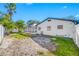 Backyard view featuring a screened pool, privacy fence, and tropical landscaping at 2217 Stacy Ct, Dunedin, FL 34698
