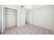 Bedroom with tiled floors, ceiling fan, and closet, offering a serene and tidy space at 2217 Stacy Ct, Dunedin, FL 34698