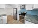 Open kitchen with stainless steel appliances, gas stove, and blue backsplash at 2217 Stacy Ct, Dunedin, FL 34698