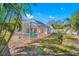 Inviting screened-in pool area surrounded by lush greenery and mature palm trees at 2217 Stacy Ct, Dunedin, FL 34698
