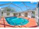 Enclosed pool area with a screened enclosure, pool, and sliding glass doors to the home's interior at 2217 Stacy Ct, Dunedin, FL 34698