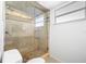 Tiled shower with glass door, river rock flooring, shower niche, and transom window at 2217 Stacy Ct, Dunedin, FL 34698