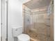 Bright tiled shower with glass door, river rock flooring, shower niche, and transom window at 2217 Stacy Ct, Dunedin, FL 34698