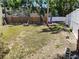 Large grassy backyard with a hammock strung between palm trees and white fence at 2512 W Texas Ave # C, Tampa, FL 33629