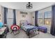 bedroom with bed, desk, bright window, blue curtains and ceiling fan at 2577 Buckthorn Loop, North Port, FL 34289
