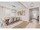 Bright dining room with a large wooden table, chandelier, and wood floors at 2577 Buckthorn Loop, North Port, FL 34289