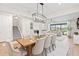Open-concept dining area featuring modern chandelier, seating for six, and seamless flow to the living area at 2577 Buckthorn Loop, North Port, FL 34289