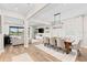 Elegant dining area with modern chandelier and open floor plan leads into the living space, offering a spacious feel at 2577 Buckthorn Loop, North Port, FL 34289
