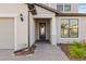 Close-up of the home's entry featuring a dark door, sidelight window and brick paver walkway at 2577 Buckthorn Loop, North Port, FL 34289