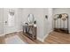 Inviting foyer featuring light walls, wood flooring, a decorative table, and a hall tree at 2577 Buckthorn Loop, North Port, FL 34289