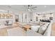 Open-concept living area with a large sectional sofa seamlessly connects to the dining area and kitchen at 2577 Buckthorn Loop, North Port, FL 34289
