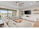 Spacious living room with oversized sectional sofa, light-filled windows, and wood flooring at 2577 Buckthorn Loop, North Port, FL 34289