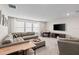 Spacious living room featuring a large sectional sofa, game table, and large windows at 2577 Buckthorn Loop, North Port, FL 34289