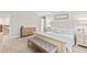 Bright main bedroom featuring a light wood bed frame, a gray upholstered bench, and light wood dressers at 2577 Buckthorn Loop, North Port, FL 34289