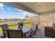 Covered lanai with comfortable seating area, dining table, and a view of the lake at 2577 Buckthorn Loop, North Port, FL 34289