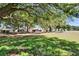 Expansive backyard featuring mature trees, lush green lawns, and a charming single-Gathering home at 322 Northway Dr, Sun City Center, FL 33573