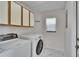 Bright laundry room with a modern washer and dryer, stylish cabinets, and sleek marble floors at 322 Northway Dr, Sun City Center, FL 33573