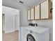 Bright laundry room with a modern washer and dryer and updated cabinets above the units at 322 Northway Dr, Sun City Center, FL 33573