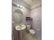 Powder room featuring tile floors, oval mirror, pedestal sink, and floral wallpaper border at 3441 Santa Rita Lane, Land O Lakes, FL 34639