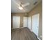 Bedroom with neutral walls and hardwood flooring, featuring three white closets at 3441 Santa Rita Lane, Land O Lakes, FL 34639