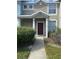 A charming townhome entrance with a red door, covered porch, and pathway for easy access at 3441 Santa Rita Lane, Land O Lakes, FL 34639