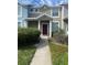This is a townhome featuring a covered front entry, with a red door, columns, grass and a walkway at 3441 Santa Rita Lane, Land O Lakes, FL 34639