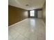 A large living room featuring tile floors, a ceiling fan, and a large window allowing natural light at 3441 Santa Rita Lane, Land O Lakes, FL 34639