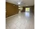 Bright living room featuring tile floors, ceiling fan, and an open layout to the kitchen area at 3441 Santa Rita Lane, Land O Lakes, FL 34639