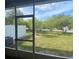 Spacious screened porch overlooking a well-maintained backyard with lush green trees and a fence at 3441 Santa Rita Lane, Land O Lakes, FL 34639