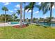 A tropical paradise with backyard pool and canal access lined by mature palms and lush green landscaping at 3945 Versailles Dr, Tampa, FL 33634