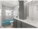 Bathroom featuring double vanity, marble tile, and a blue tub, offering both style and functionality at 3945 Versailles Dr, Tampa, FL 33634