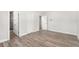Spacious bedroom featuring wood-look floors, base molding, and access to an ensuite bathroom at 3945 Versailles Dr, Tampa, FL 33634