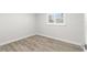 Inviting bedroom featuring wood-look floors, neutral paint, and bright window with white shutters at 3945 Versailles Dr, Tampa, FL 33634