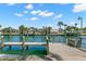 A waterfront retreat featuring a private wooden dock for boating and scenic water views under a partly cloudy sky at 3945 Versailles Dr, Tampa, FL 33634