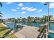 A waterfront retreat featuring a private wooden dock for boating and scenic water views under a partly cloudy sky at 3945 Versailles Dr, Tampa, FL 33634