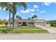 Beautifully landscaped front yard complements this bright, white single-story home with a two-car garage at 3945 Versailles Dr, Tampa, FL 33634