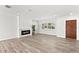 Living room with wood-look flooring, a modern fireplace, and large windows providing ample natural light at 3945 Versailles Dr, Tampa, FL 33634