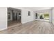 Spacious living room with sliding glass doors, wood-look tile flooring, and an open floorplan at 3945 Versailles Dr, Tampa, FL 33634