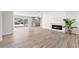Spacious living area featuring a modern fireplace, wood-look floors, and sliding glass doors with backyard access at 3945 Versailles Dr, Tampa, FL 33634